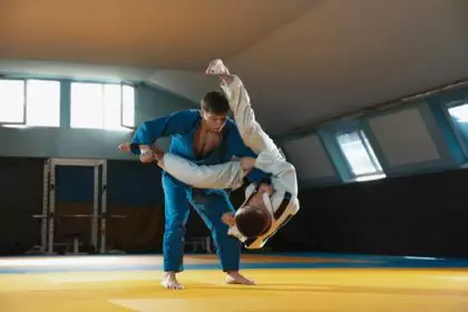 Two young judo fighters in kimono training martial arts in the gym with expression, in action and