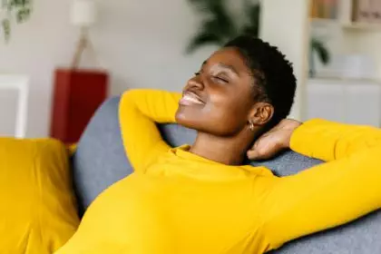 Young African American woman relaxing on a sofa at home.