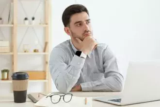 Young man spending time in office trying to find solution to problem or optimize business process