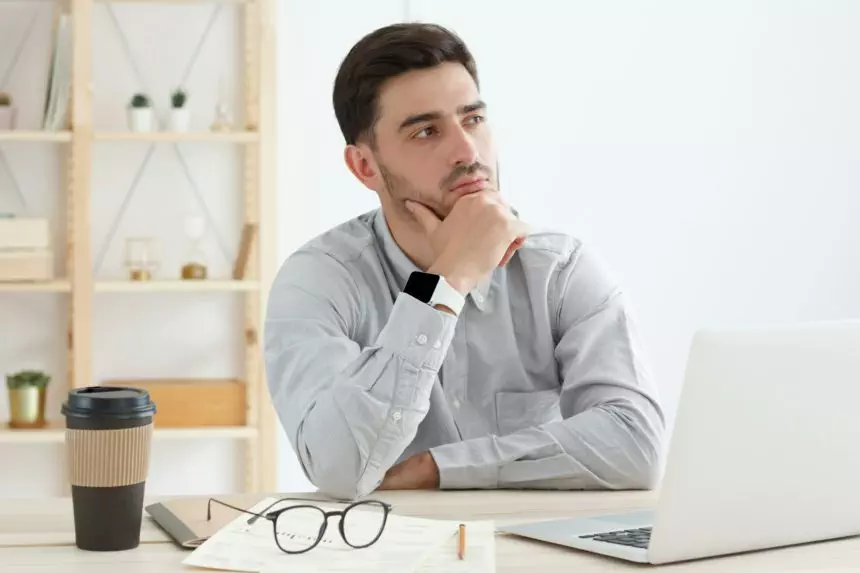 Young man spending time in office trying to find solution to problem or optimize business process