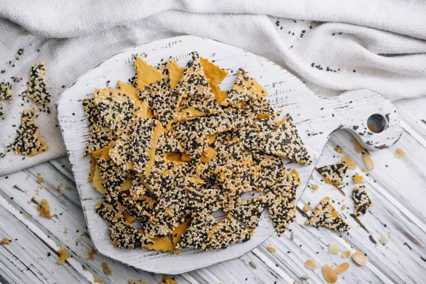 Salted tortilla chips triangle with chia seeds on top view
