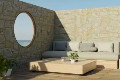 Beautiful outdoor terrace design with comfortable couch, circle window with beach view, stone wall.