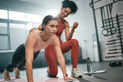 Personal trainer, fitness and stopwatch with a black woman coaching a client in a gym during her wo