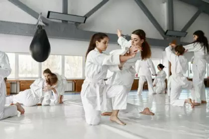 Teenage girls fighting at aikido training in martial arts school