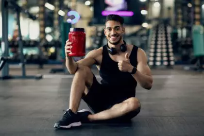 Handsome Muscular Middle Eastern Guy Advertising Fitness Supplements While Posing At Gym